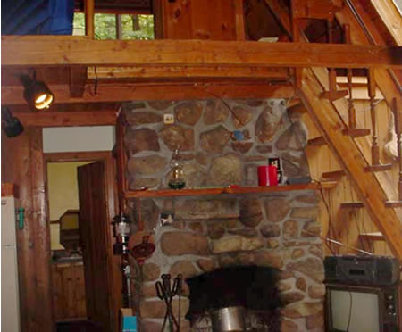 Sliding glass doors to stone patio with outdoor fireplace.